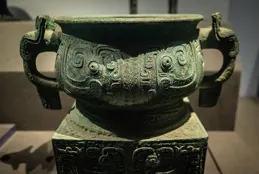 清晨的北京古玩城中，李飛正擦拭那些放置得整整齊齊的文物（一）